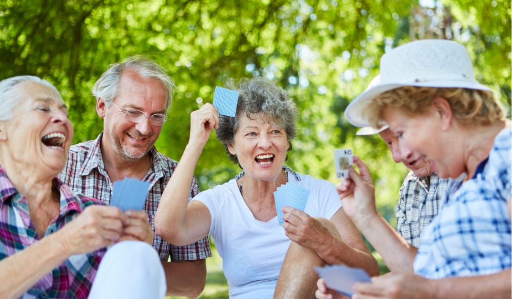 summer senior friends playing cards outside