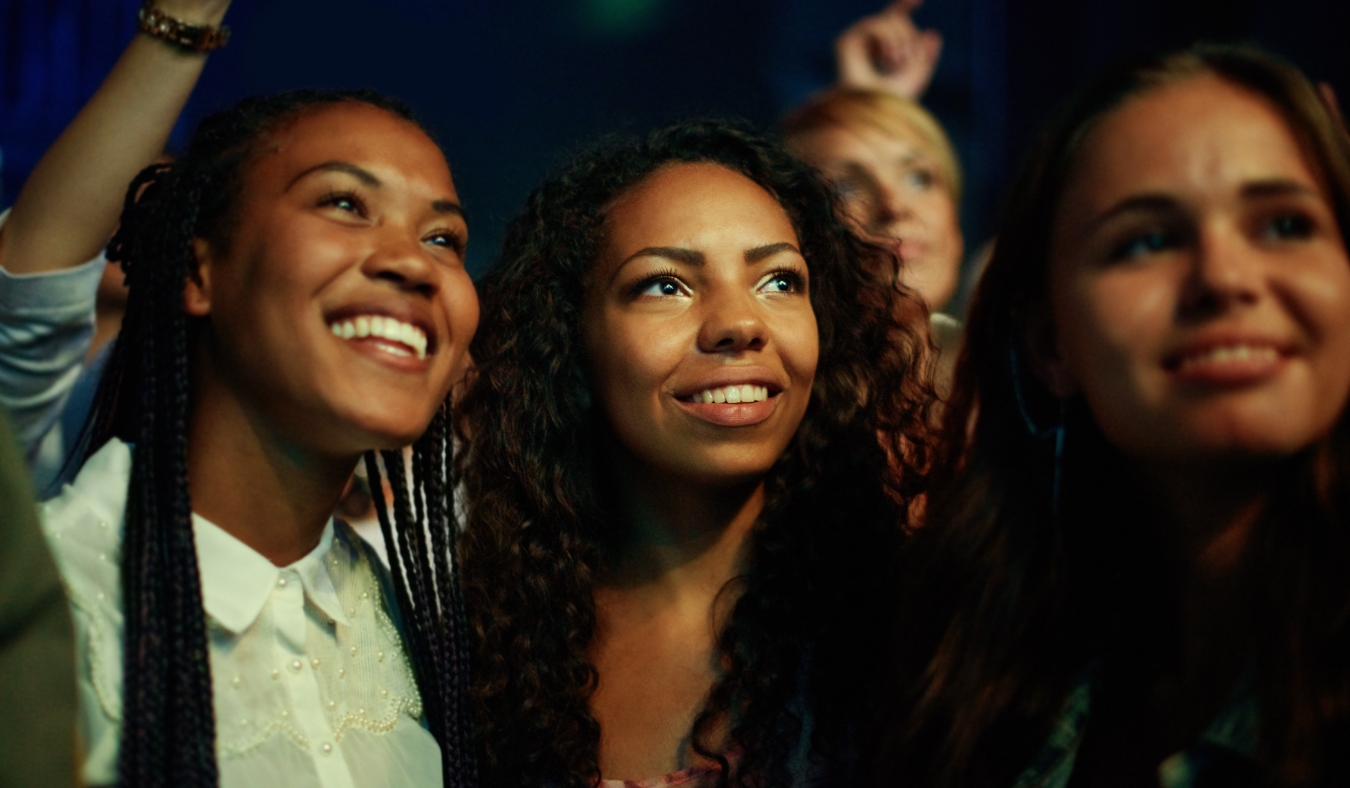 three friends attending music concert festival