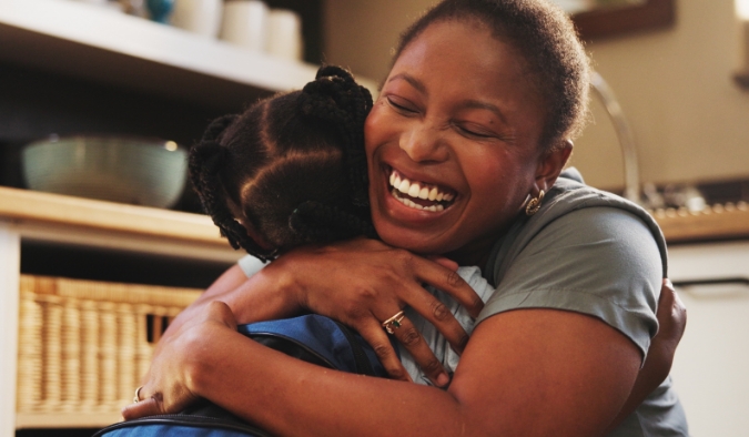 mother hugging young daughter smiling