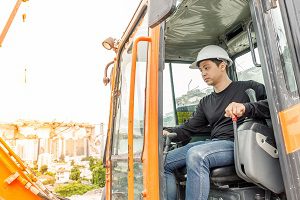 man in cabin of construction vehicle