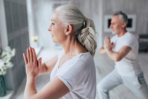 husband and wife doing yoga at home