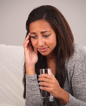 woman with minor ear pain sitting on her couch