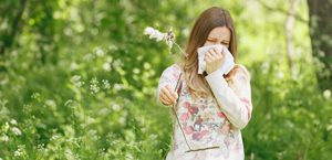 woman outdoors is suffering from allergies