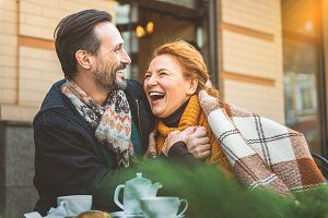very happy couple laughing outside on cold autumn day