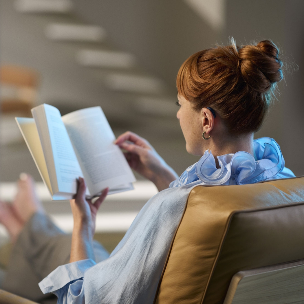 ReSound Vivia lifestyle woman wearing bte hearing aids white reading