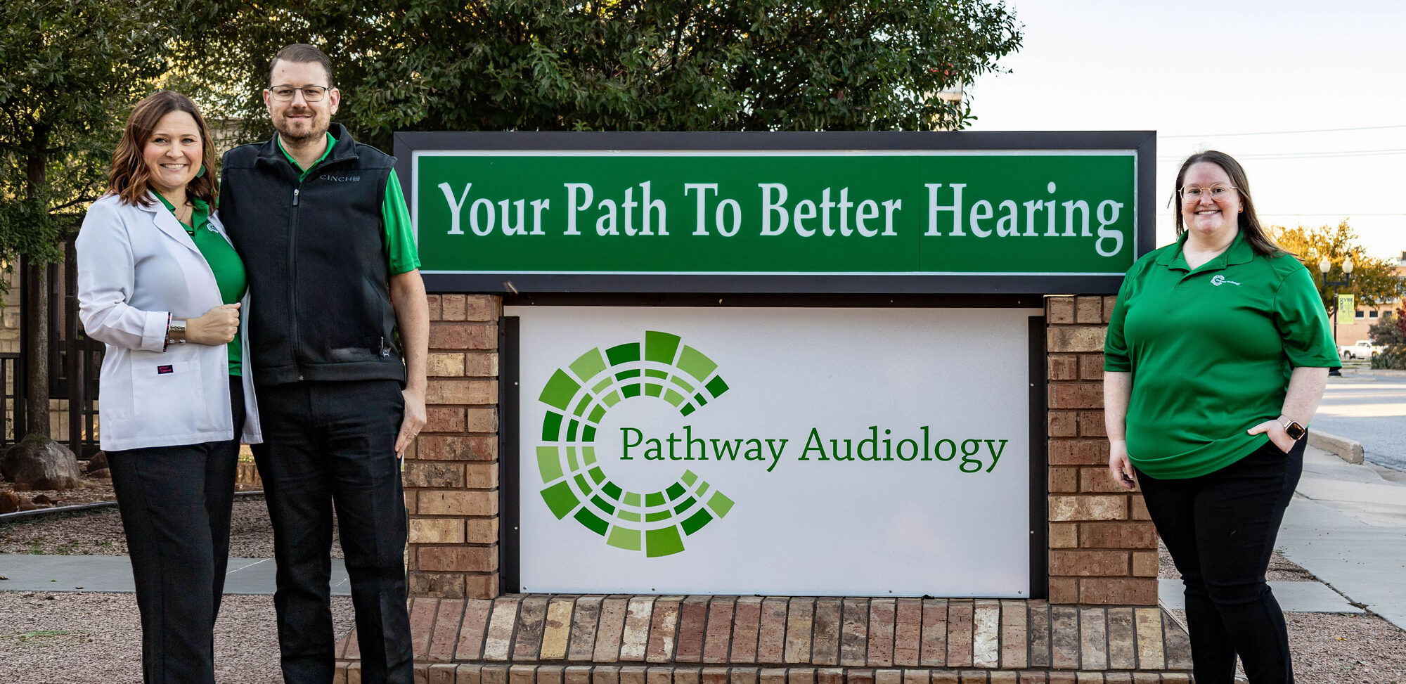 Dr Marisha Beck husband and staff in front of signage