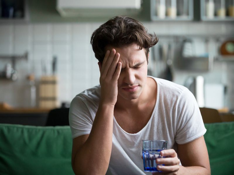 man with head in hands due to his tinnitus