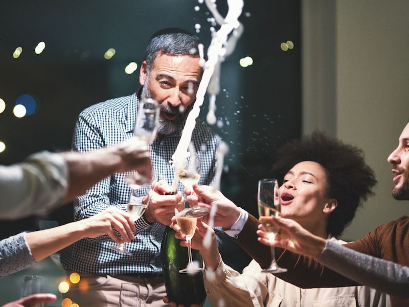 group of people popping a bottle of champagne