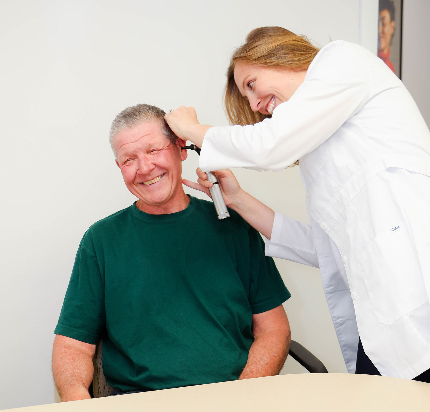 danielle burke checking patients ear with otoscope