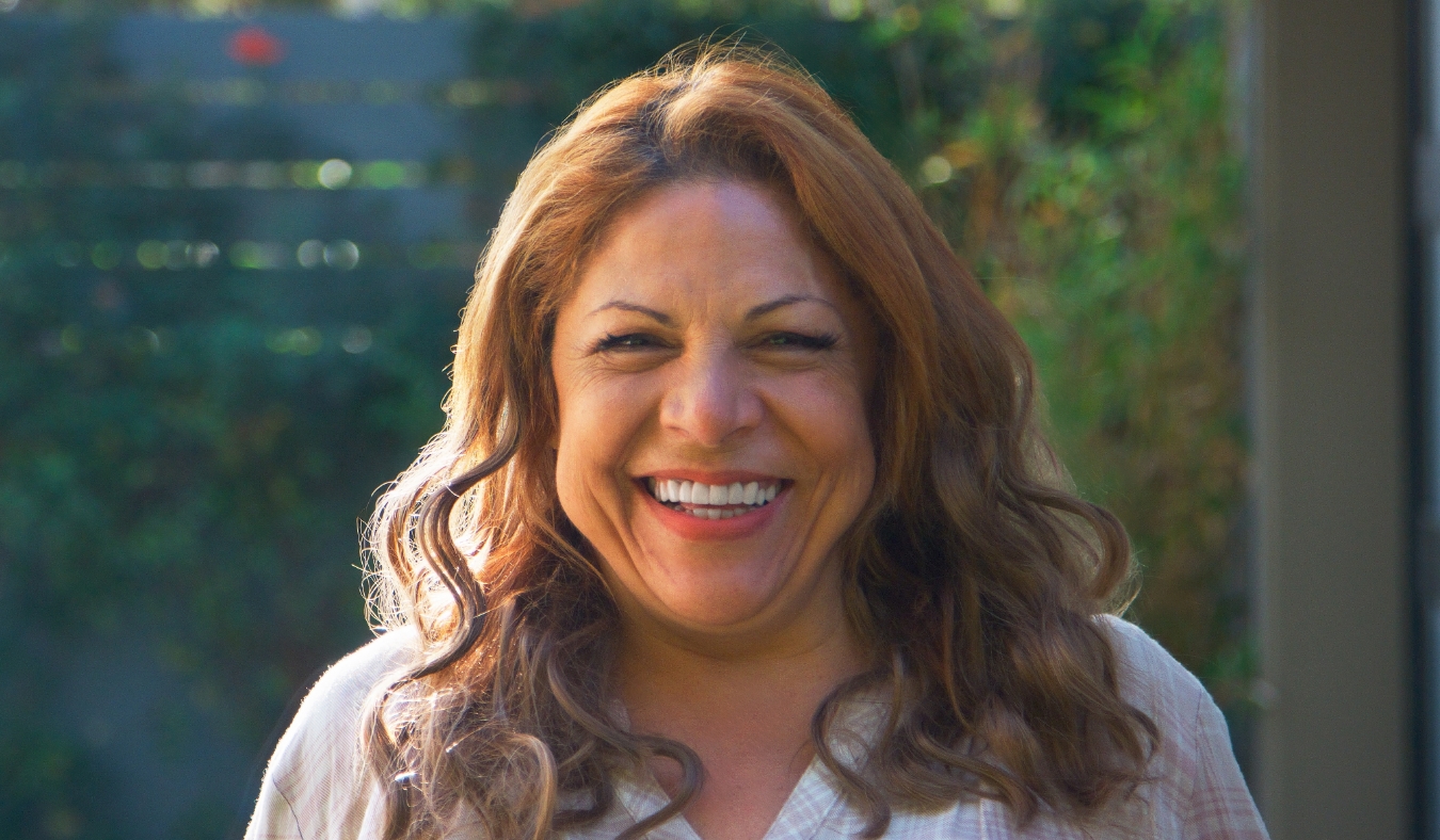 smiling senior hispanic woman in garden at home