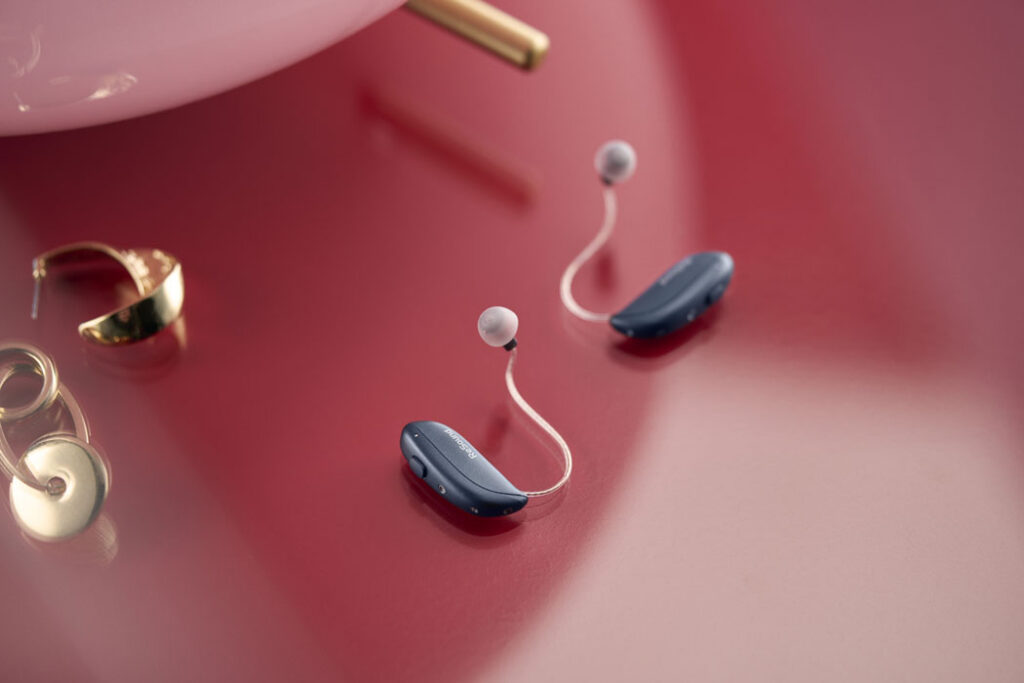 ReSound Vivia lifestyle hearing aids on table lifestyle graphite