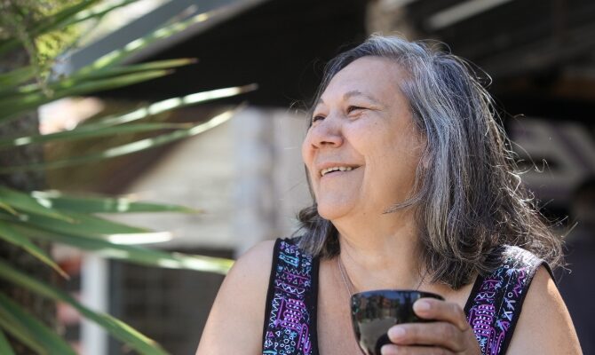 cta stacked senior latina woman drinking tea outside
