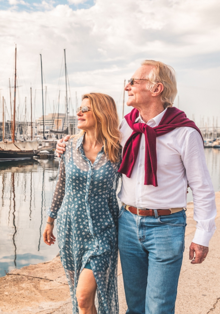 senior couple walking along bay docks