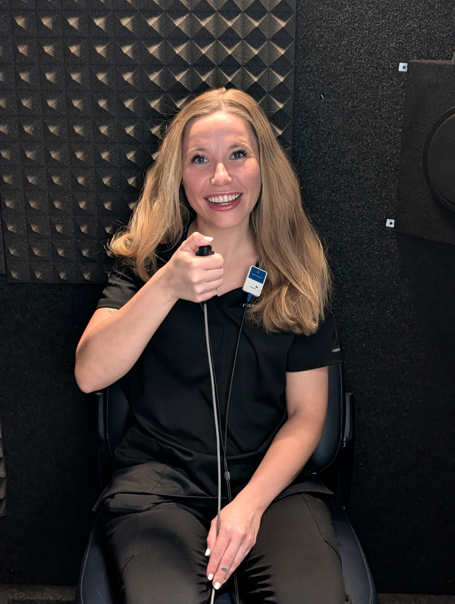 woman taking hearing exam in sound booth