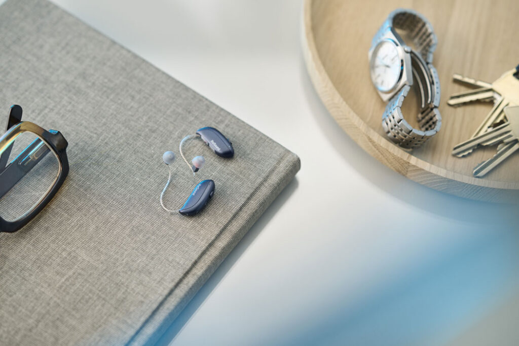 ReSound Vivia lifestyle hearing aids on book lifestyle graphite