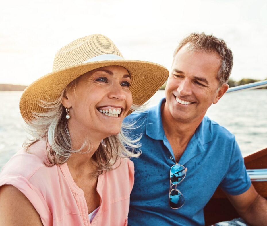 middle aged white couple smiling riding boat on lake
