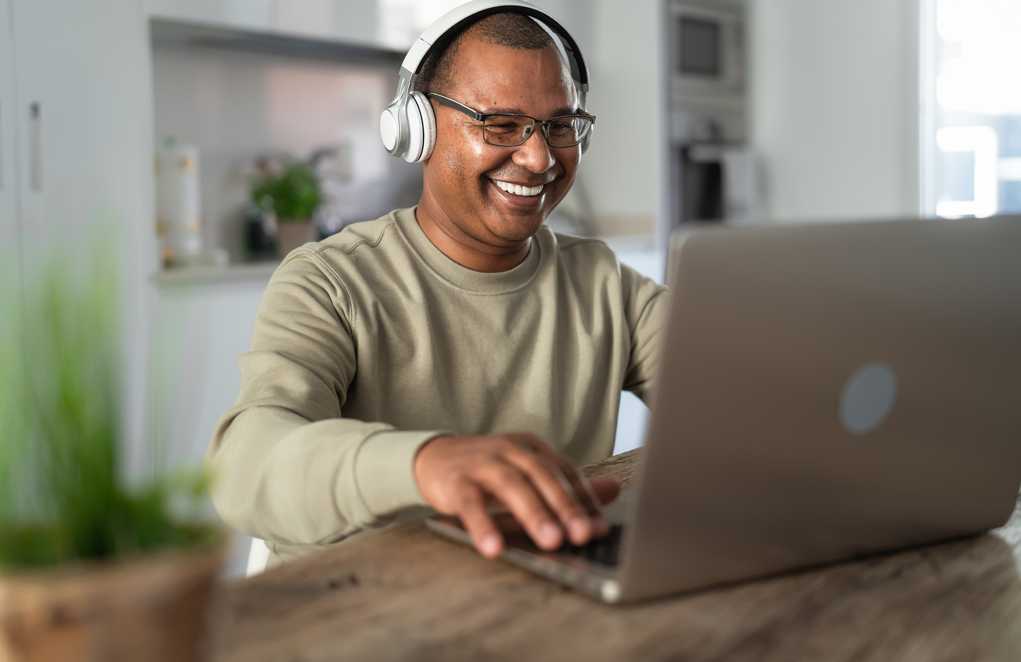 man using laptop with headphones for virtual appointment