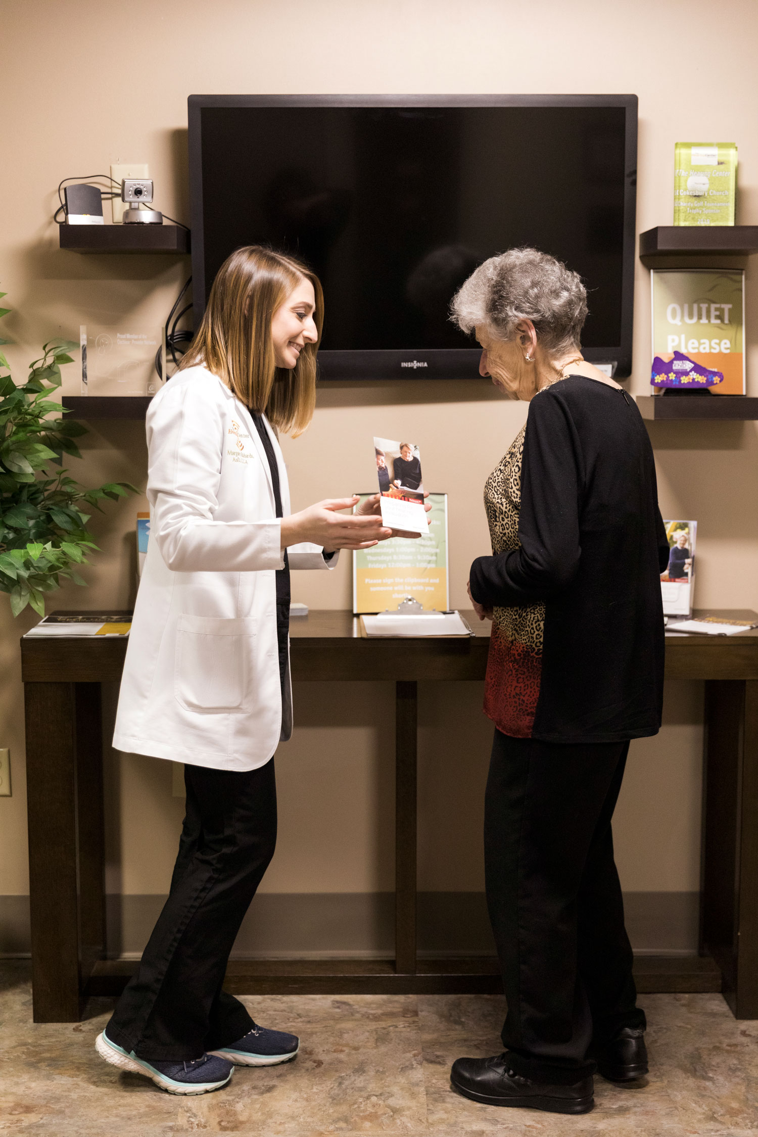 Hearing Center Branding showing hearing aid phamlet to senior woman
