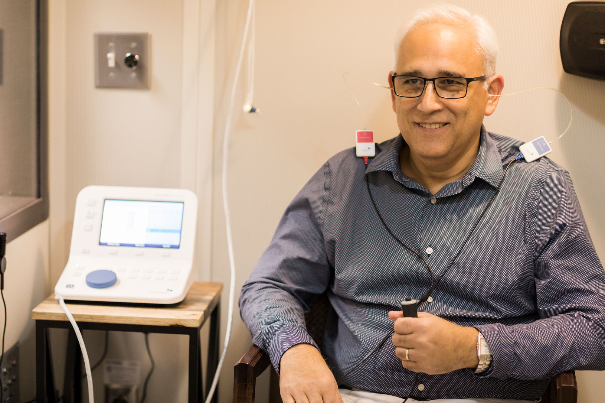 The Hearing Center man taking hearing comprehensive hearing assessment in sound booth