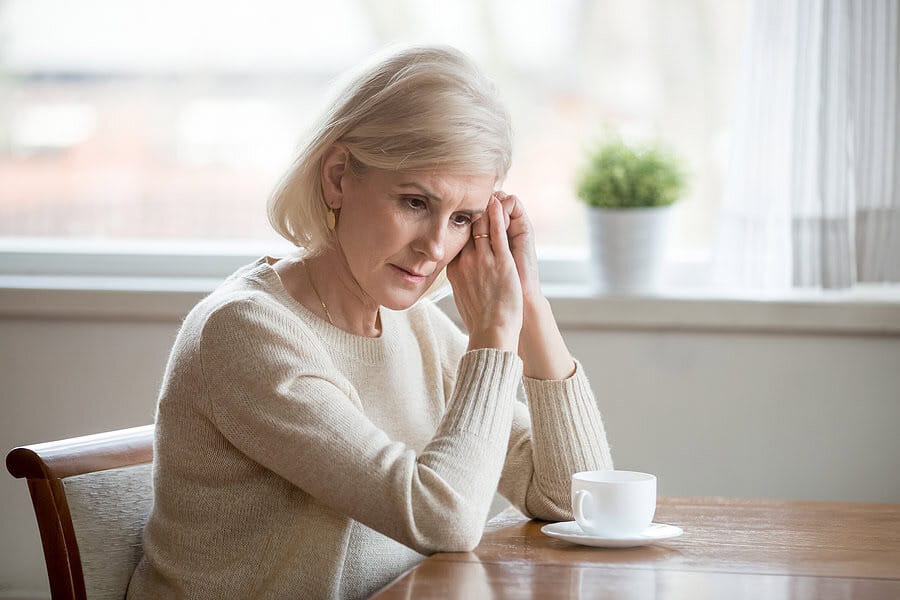 bigstock Concerned Aged Woman Sit At Ta 269100064