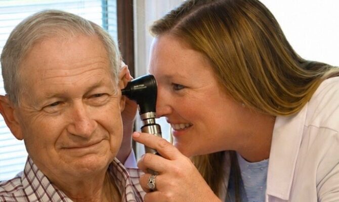 provider looking at patient ear with otoscope