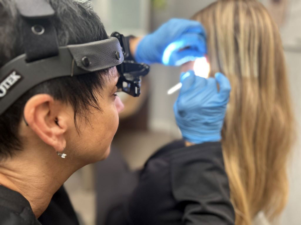 Christina Beer inspecting patients ear