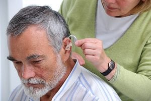 an older gentleman having a hearing aid fitted