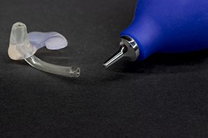 hearing aid laying next to cleaner bottle