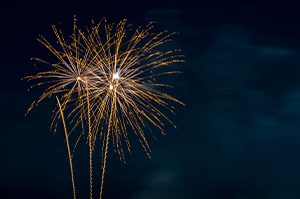 gold fireworks against a dark black sky