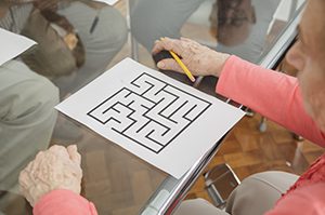 SENIOR WOMan working on brain puzzle