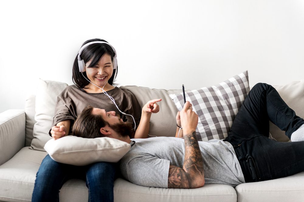 husband and wife listening to music on couch