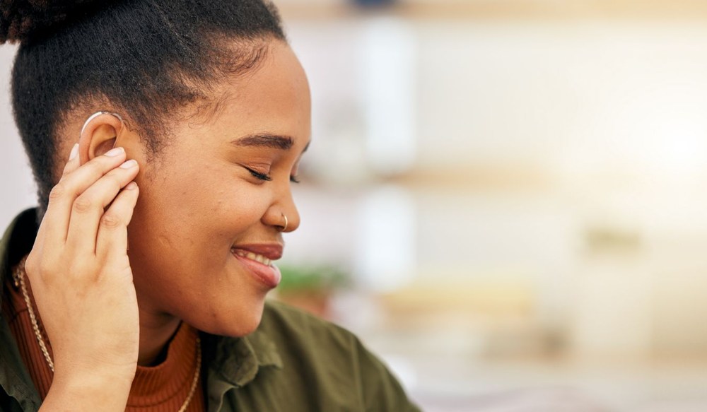 hearing aid on ear young african american woman