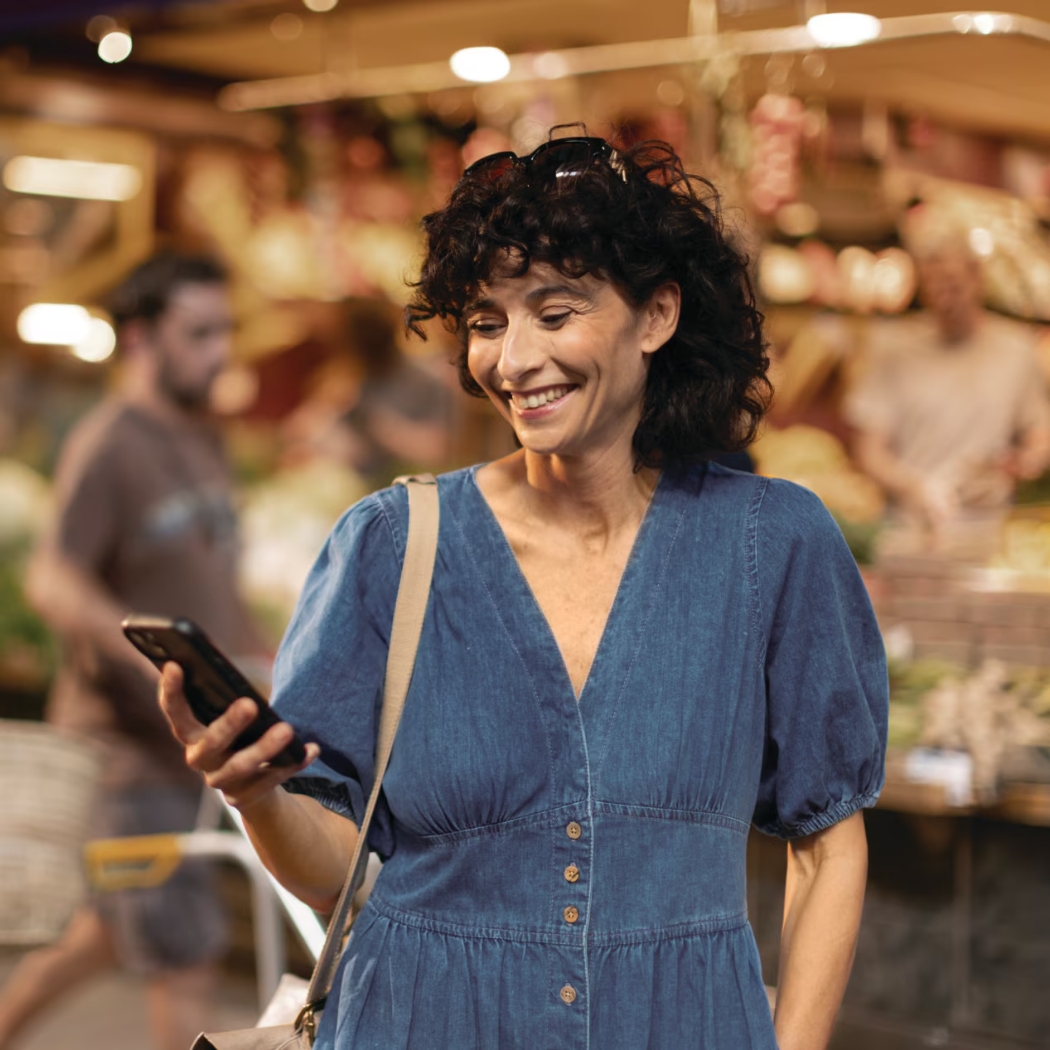 phonak audeo r infinio lifestyle woman on phone in market connectivity