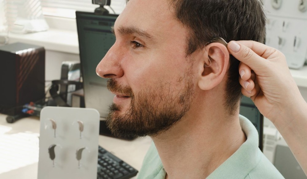 hearing aid on ear young man fitting