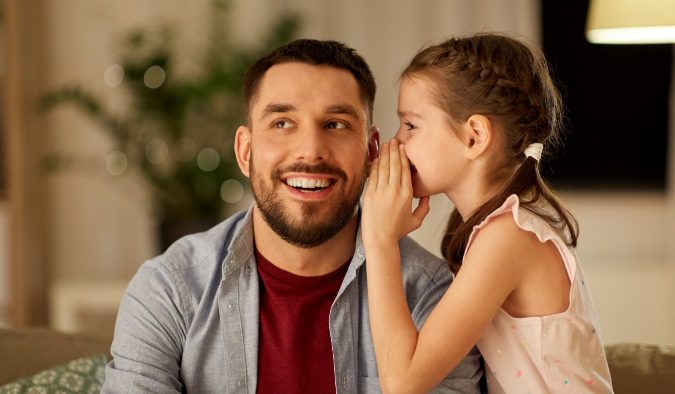 event image young girl whispering to adult man