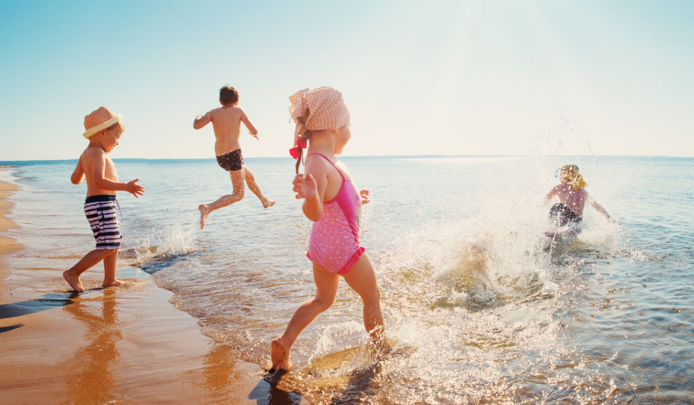 beach children running jumping into ocean
