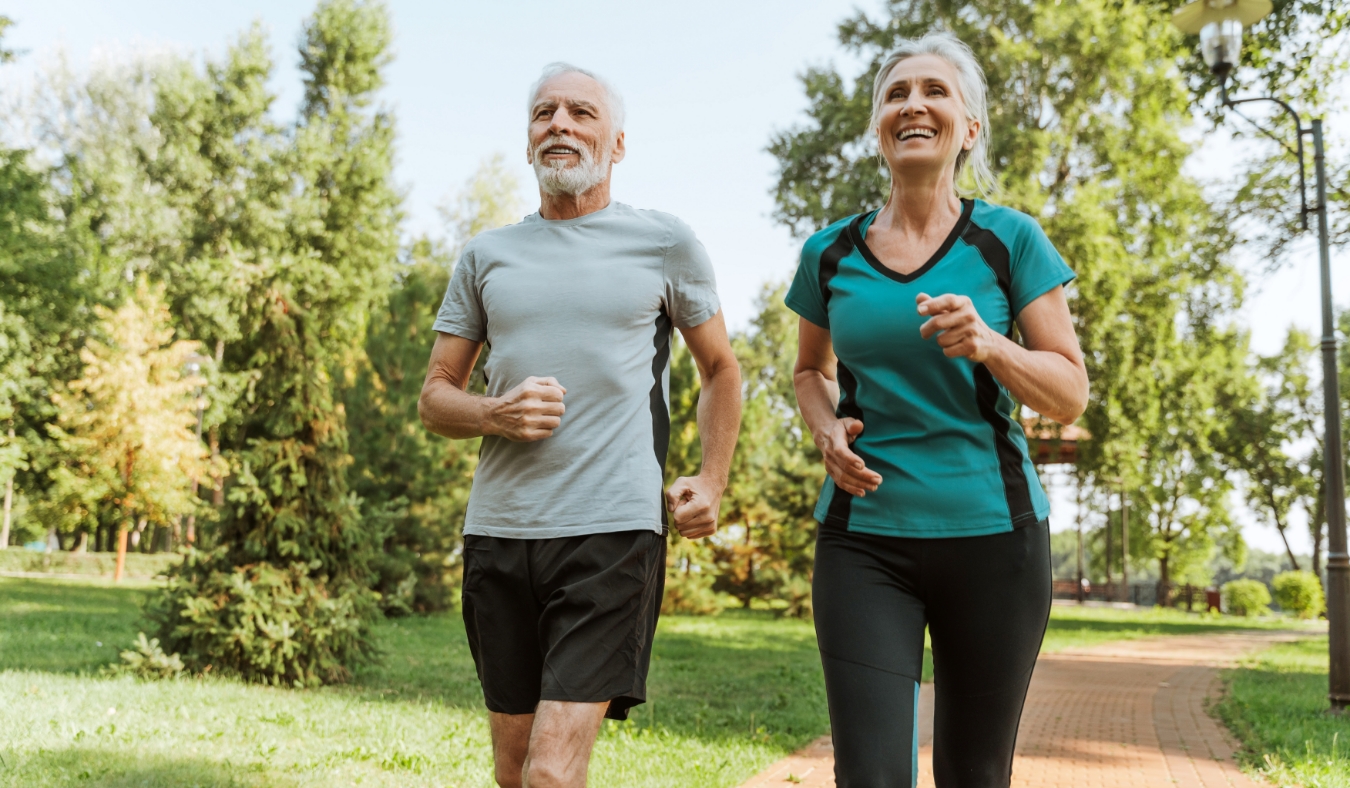 senior couple jogging together in a park