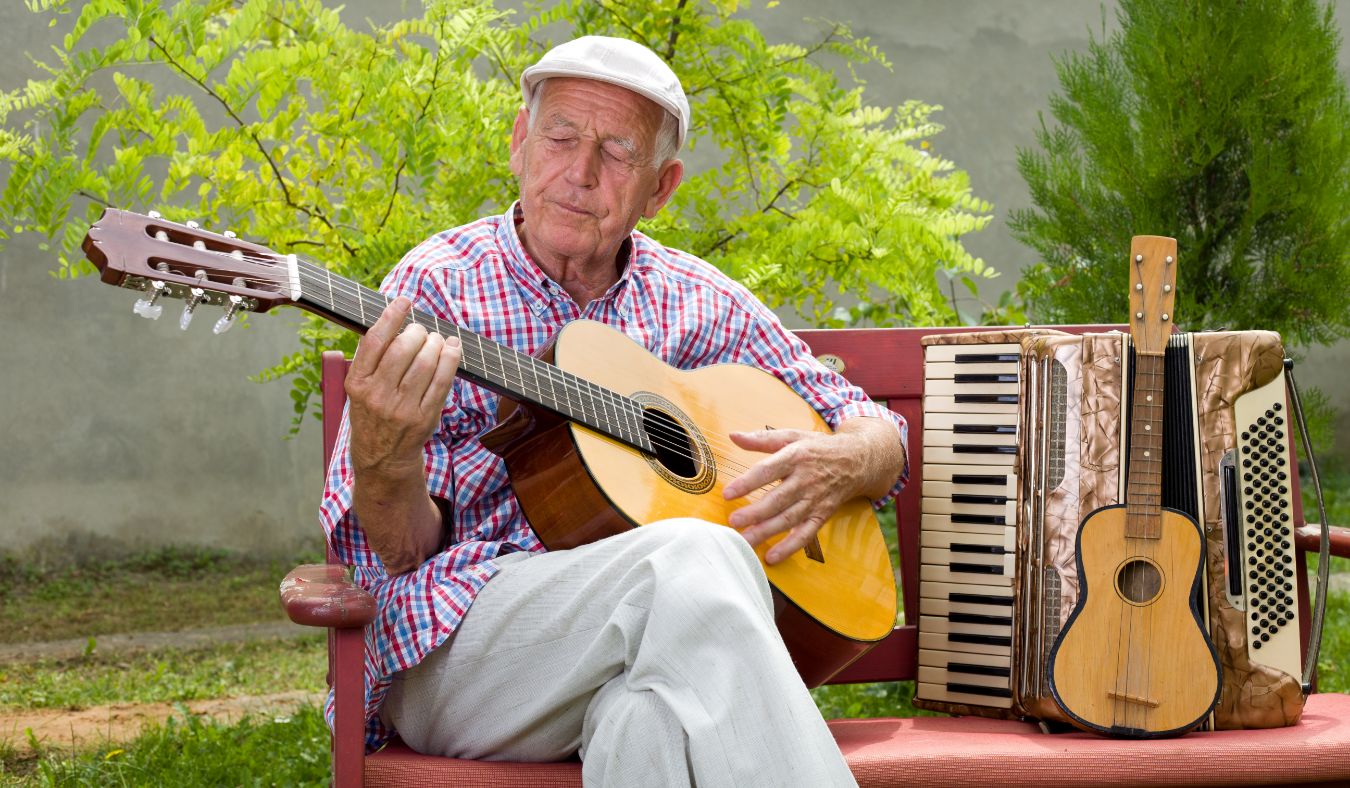 senior man playing guitar