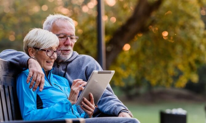 cta stacked senior couple looking at tablet outside