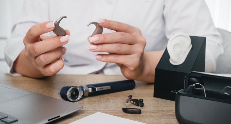 cta stacked audiologist discussing and holding hearing aids