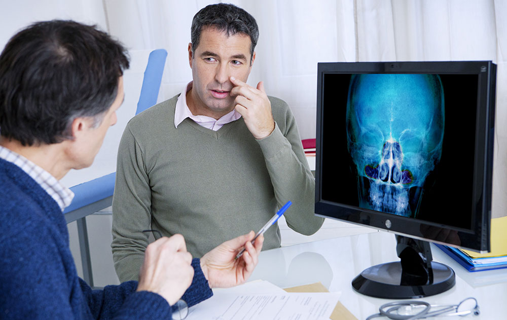 man pointing to his sinus area