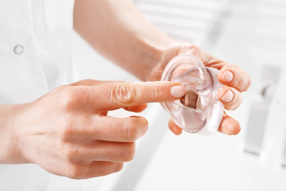 hearing aid demonstration inside clear plastic model ear