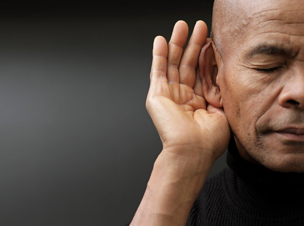 deaf man suffering from deafness and hearing loss on grey background with people stock image stock photo