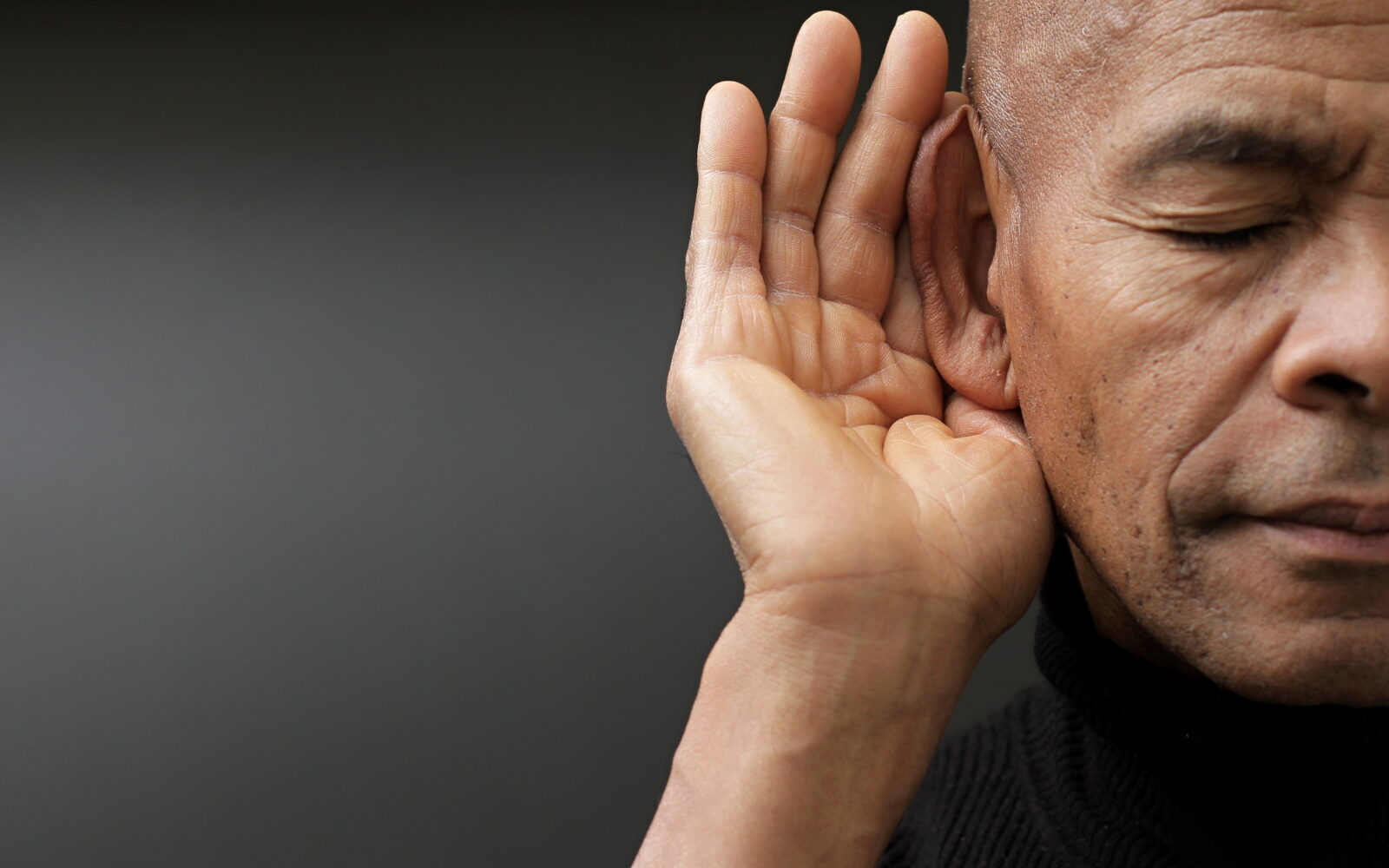 deaf man suffering from deafness and hearing loss on grey background with people stock image stock photo