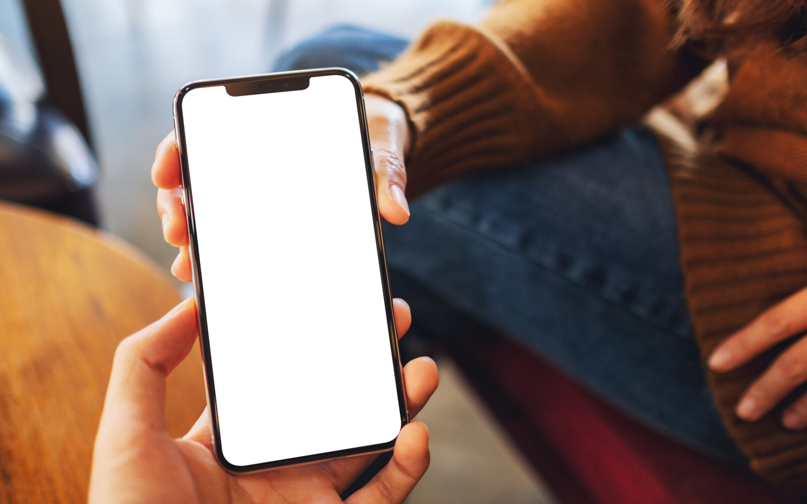 Mockup image of a woman holding and showing white mobile phone w