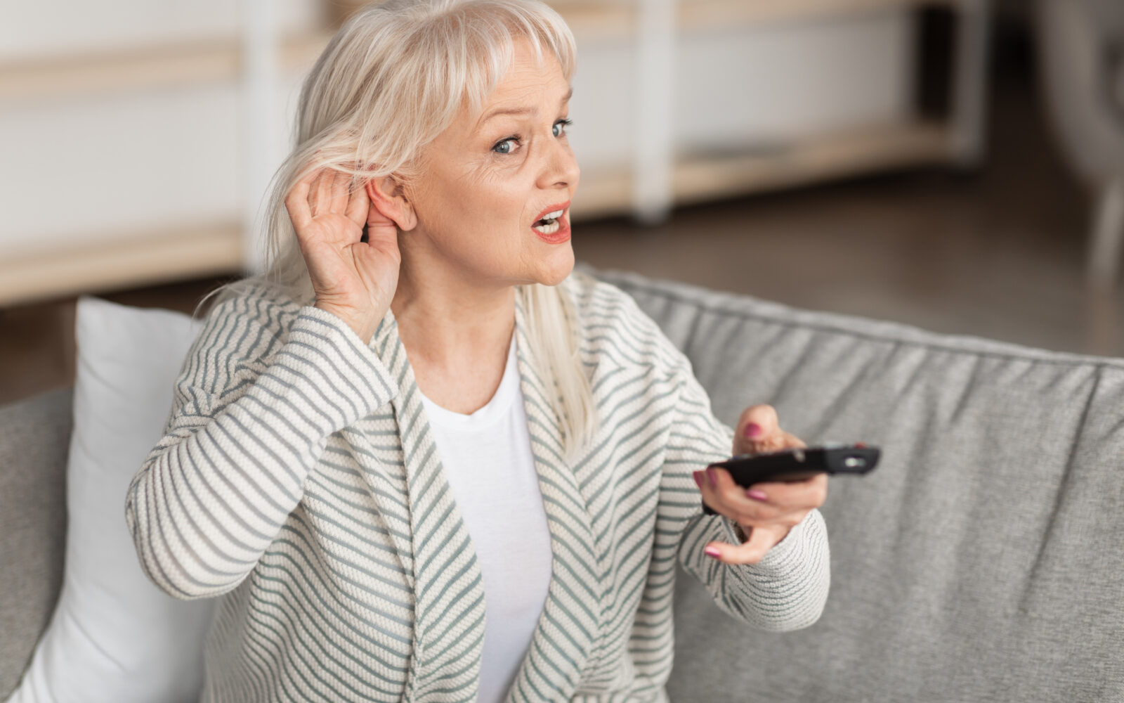 Hearing Problems Mature woman watching television sitting on couch