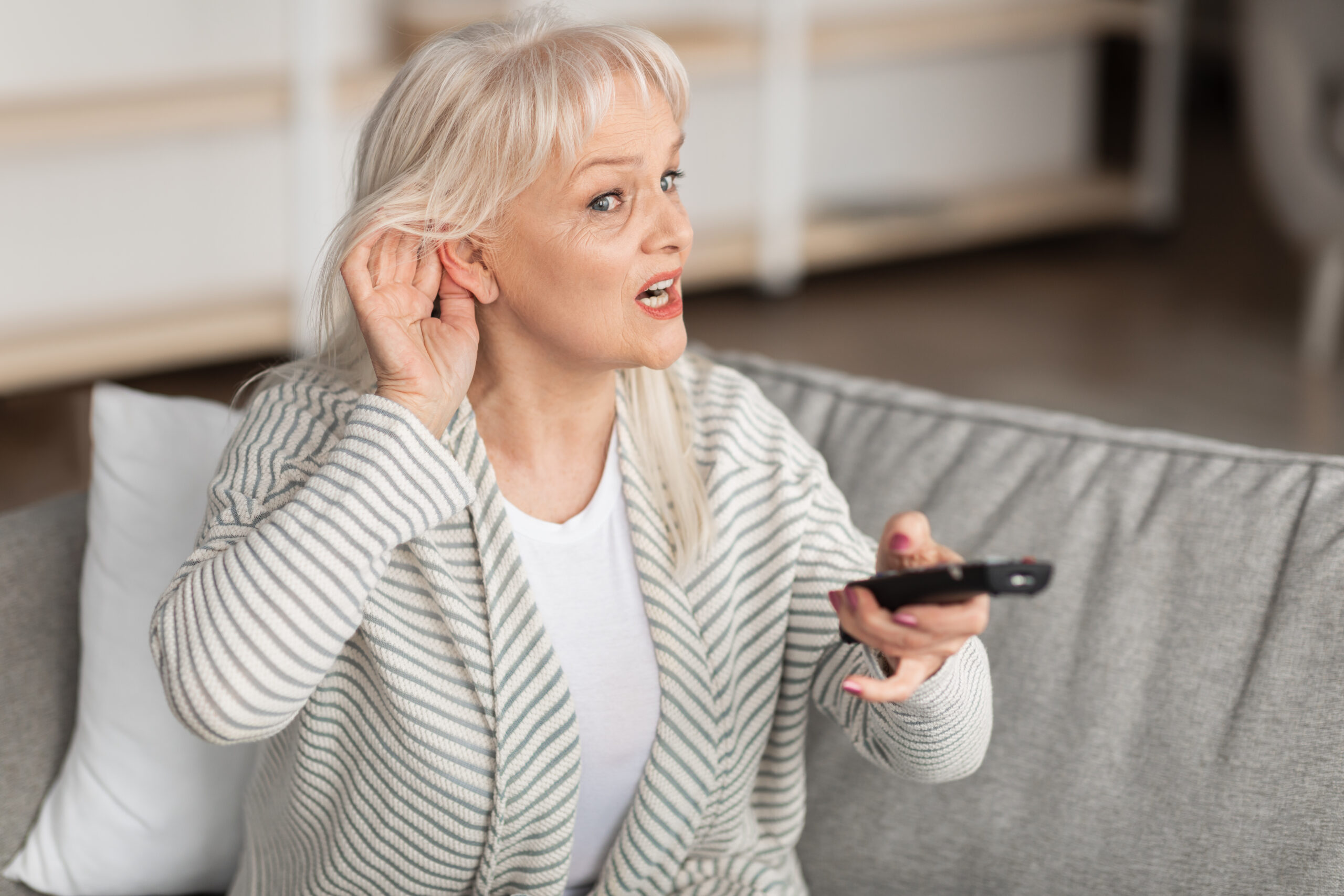 Hearing Problems Mature woman watching television sitting on couch