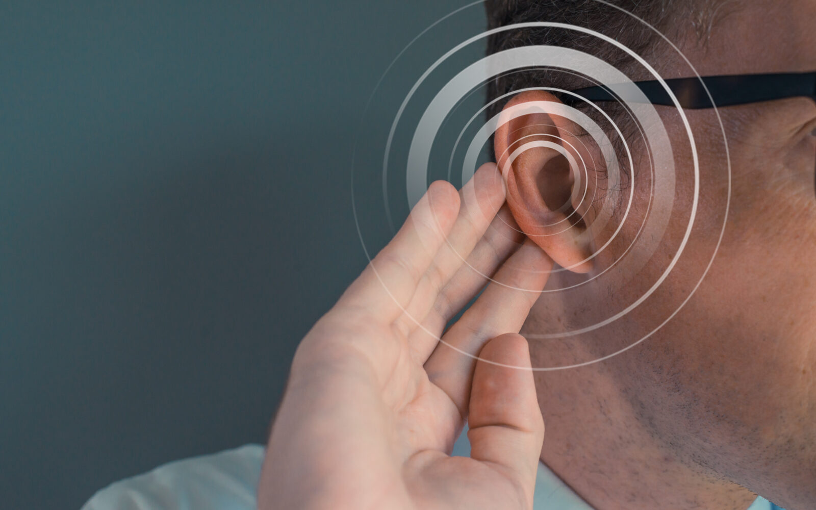 Man putting his hand on his ear Deficiency hearing acousting problem Empty space on the left