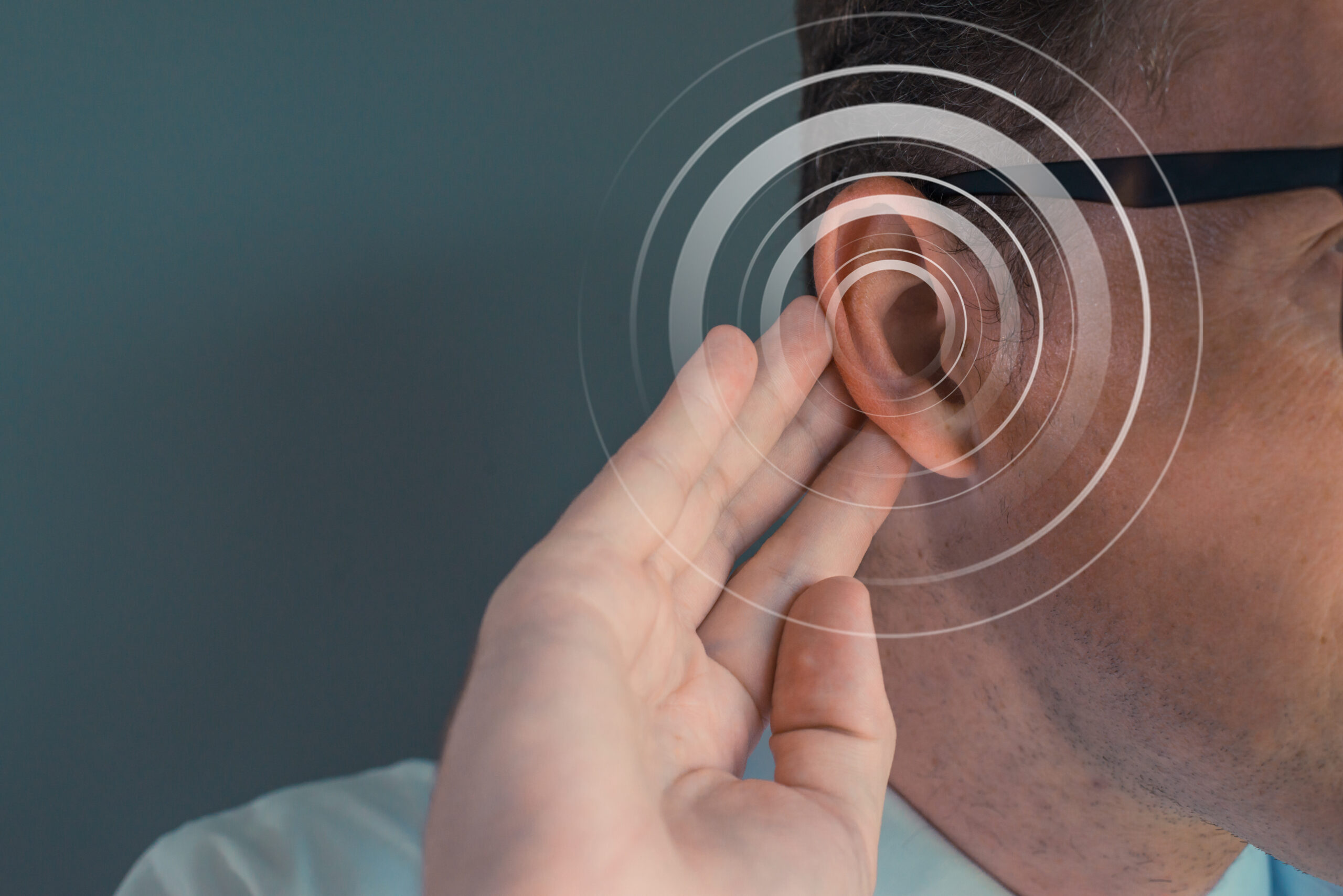 Man putting his hand on his ear Deficiency hearing acousting problem Empty space on the left