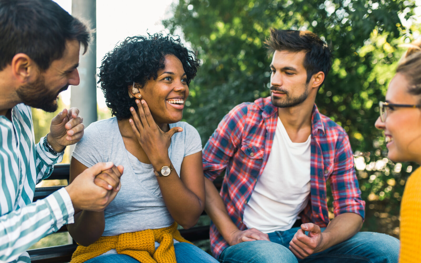 Woman with ear hearing problem having fun with her friends in th